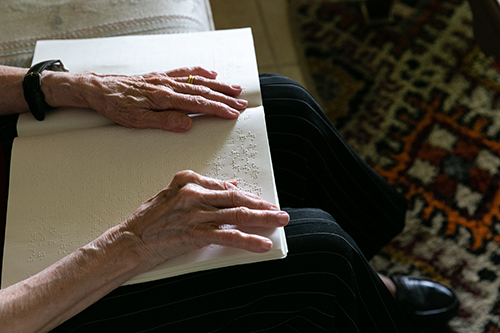 Cuban-American Adelina Maideski, a former gift store employee at Miami International Airport who attends St. Martha Parish in Miami Shores, reads braille Catholic materials at her residence.