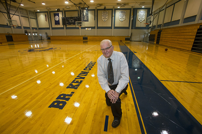 El Hermano Marista Kevin Handibode, presidente de la escuela secundaria Columbus, se retrata en la cancha de baloncesto que lleva su nombre.