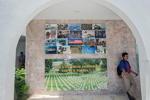 Un alumno de Christopher Columbus High se toma un segundo de descanso junto al muro conmemorativo del Ejército de los EEUU.