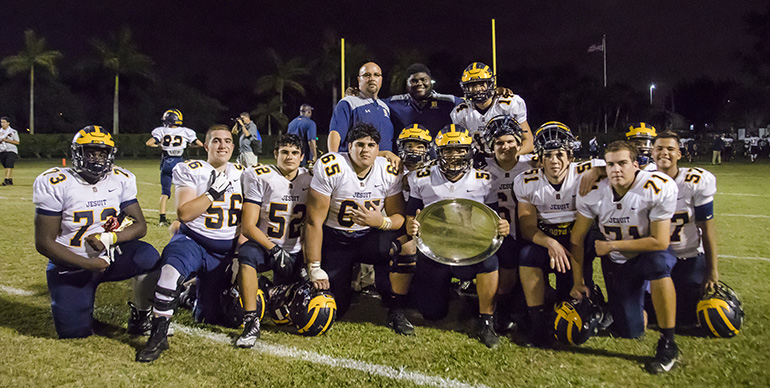 Belen's Wolverines pose with their Turkey Bowl trophy, which entitles them to bragging rights for another year. The annual Knights of Columbus Turkey Bowl match-up between Monsignor Edward Pace High School and Belen Jesuit Preparatory School took place on November 2. The winner of the game receives a silver platter engraved with the helmets from each team and the years and final scores of their previous games. Money raised goes towards the Knights Thanksgiving Drive.