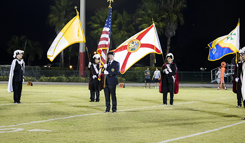 The Knights of Columbus, Coral Gables Council 3274 stand on center field during the Pace vs Belen match-up at the annual Turkey Bowl. The Knights led the opening ceremony  at the November 2 football game. The net profit from the game and pledges from each team went to the Knights Thanksgiving food drive.