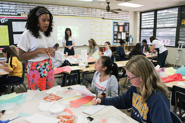 Amber Kemp-Gerstel gets a little press time as she is interviewed by Nativity School Knightly News reporters Nicole Chang (center) and Elise Graham (right).