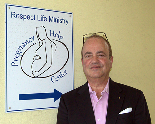 Juan Guerra poses at the entrance of the South Broward pregnancy help center. It's part of the archdiocesan Respect Life Office, where he's the new executive director.