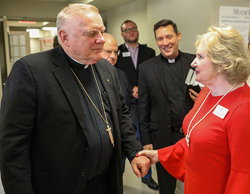 Archbishop Thomas Wenski speaks with Virginia A. Jacko, president and chief executive officer of the Miami Lighthouse for the Blind & Visually Impaired, during a visit to the facility Nov. 8, 2018.