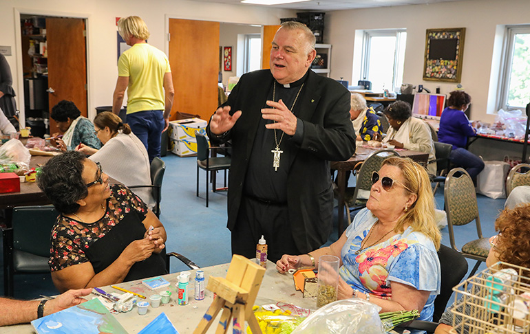 Archbishop Thomas Wenski speaks with participants in the Miami Lighthouse for the Blind's Senior Group Health and Activities Program during a visit to the facility Nov. 8.