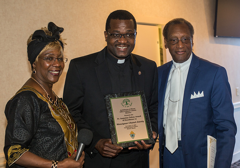 Katrenia Reeves Jackman, director of the archdiocesan Office of Black Catholic Ministry, poses with Msgr. Chanel Jeanty, the ministry's chaplain, who was honored with a special award, the Father Augustus Tolton award of excellence. At right is Donald Edwards, associate superintendent of schools for the archdiocese.