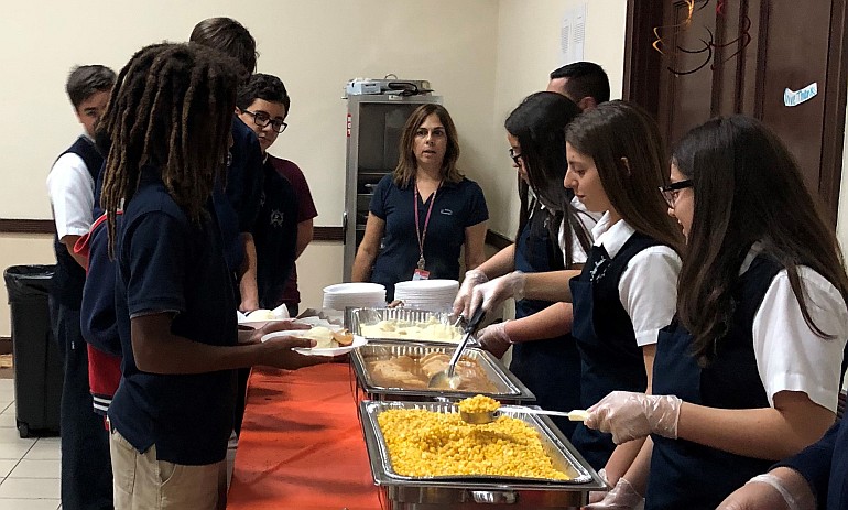 Eighth-graders at St. Brendan School serve Thanksgiving dinner to children from Branches of South Florida.