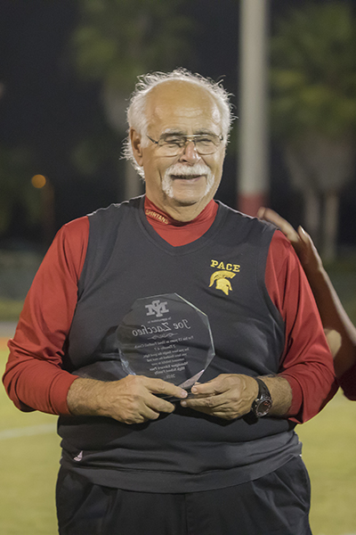 Retiring Pace football coach Joe Zaccheo receives a commemorative plaque Nov. 2, when the Pace Spartans and the Belen Wolverines had their annual match-up at the Knights of Columbus Turkey Bowl.