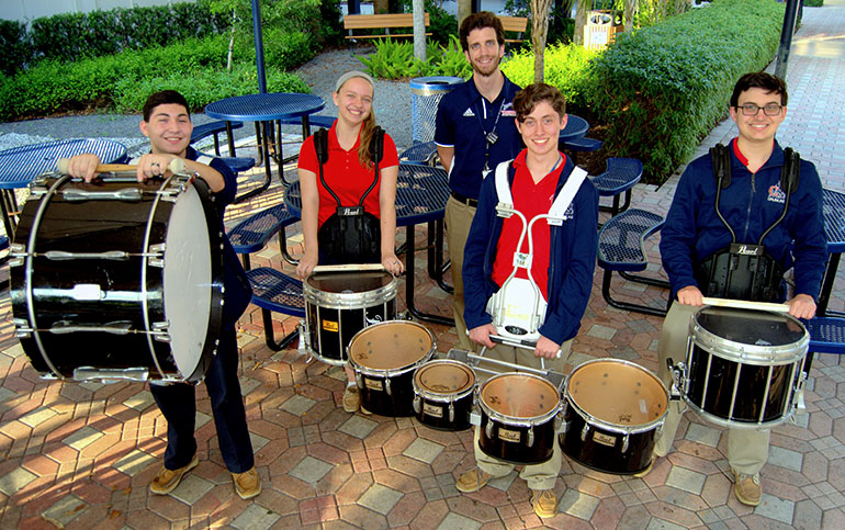 Presidents of the Chaminade-Madonna High School drumline, are, from left, Justin DiFrancesco, Taylor Despars, Fabian Carrillo and John Mendez. Behind them is their instructor, Carlo Ricchi. The drumline has been invited to perform at Christmas Near the Beach, a community holiday celebration.