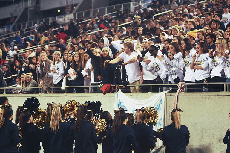 St. Thomas Aquinas cheerleaders and the student section exchange cheers during the first half Friday.