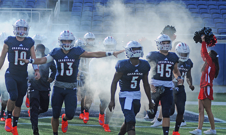 Chaminade-Madonna's football team runs through the spirit line before their FHSAA 3A state football final against West Palm Beach King's Academy.