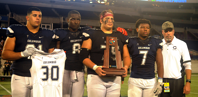 Columbus captains (from left) Dylan Perez, Jeramy Passmore, Luis Cristobal and Jordan Griffin pose with coach Chris Merritt with the runner-up trophy. Perez is holding up the No. 30 of defensive back Ari Arteaga, who died July 28 in a car wreck.