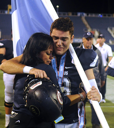 Columbus quarterback Armando Parra is consoled by Columbus fan Minnie Catala, president of the Columbus High Quarterback Club, after the Explorers' 37-35 loss to Mandarin in the FHSAA 8A football final Dec. 8.