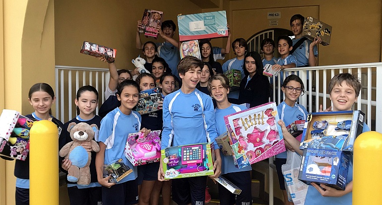 St. Agnes Academy students show some of the 1,000 toys the school collected for the Centro Mater Child Care Center in downtown Miami.