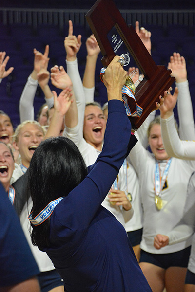 St. Thomas Aquinas volleyball players cheer as their coach holds up their state championship trophy Nov. 17 in Fort Myers.