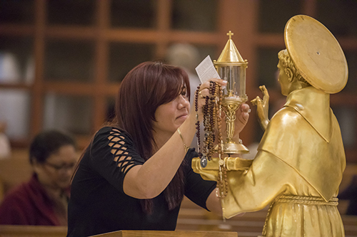 Eysac Aquino, parishioner at St. Mark Church in Southwest Ranches, prays in front of a relic of St. Anthony of Padua that was venerated at the church Dec. 3. Two relics from the basilica in Padua, Italy, traveled through South Florida churches Nov. 30-Dec. 9.