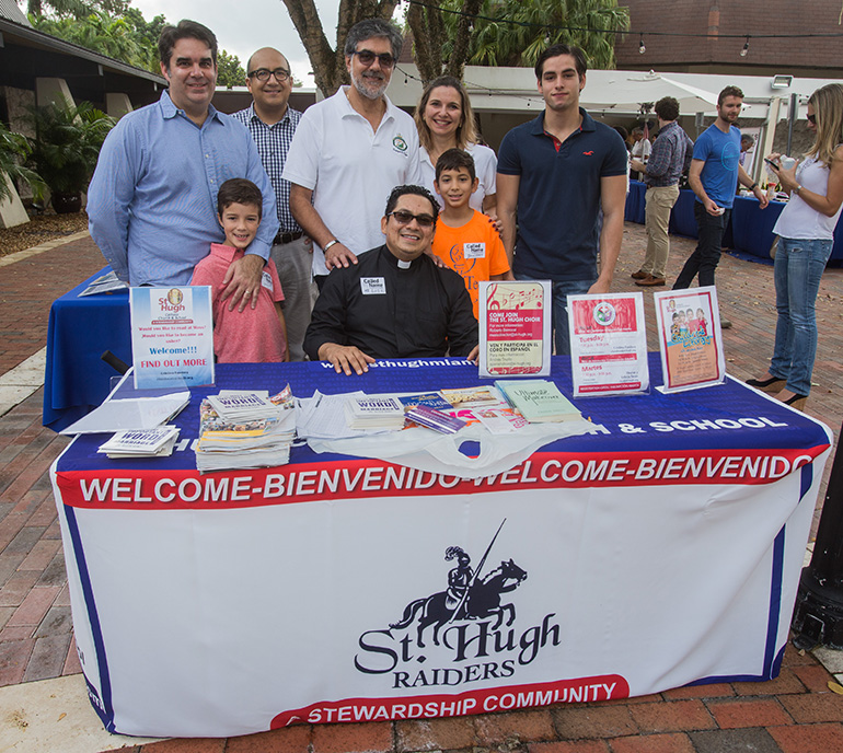 A group of parishioners pose with Father Luis Largoespada, St. Hugh's pastor, at the welcome table that greeted parishioners and visitors the weekend of Dec. 8-9, Welcome Weekend in the Archdiocese of Miami.