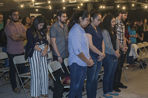 Young adults pray before Archbishop Thomas Wenski speaks to them at Theology on Tap Dec. 20.