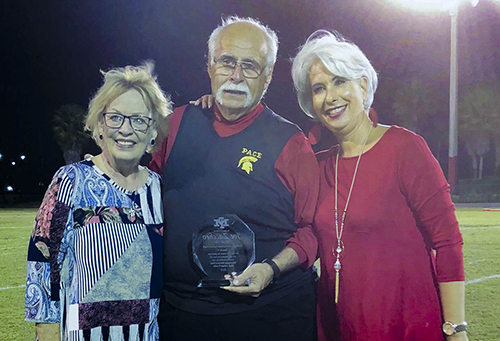 Msgr. Pace High School football coach Joe Zaccheo is pictured here with wife, Carol, left, and Pace principal Ana Garcia, after being recognized at the annual Turkey Bowl between Belen and Pace in November 2018.