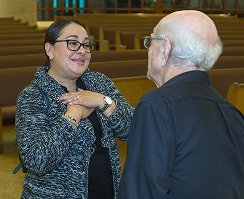 Parent Lesley Gray talks to Deacon John Lorenzo at the conclusion of one of the mandatory meetings for parents of religious education students.