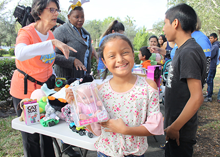 La niña guatemalteca Maili López, de 9 años, muestra el juguete que recibió por el Día de los Reyes Magos frente a las oficinas del ICE en Miramar, a donde acompañó a sus padres a su cita de inmigración, el 9 de enero.