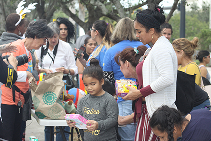 La niña Luci Chemay y su mamá Luciela Manzano, observan un juguete que escogieron por el Día de los Reyes Magos, frente a la oficina de ICE, en Miramar.