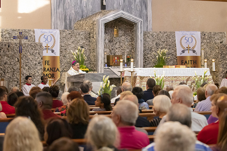 Auxiliary Bishop Enrique Delgado gives the homily during  the Mass marking the start of a year-long celebration of St. Henry Church's golden jubilee.