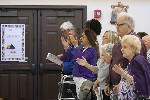 Parishioners pray during the Mass marking the start of a year-long celebration of St. Henry Church's golden jubilee.