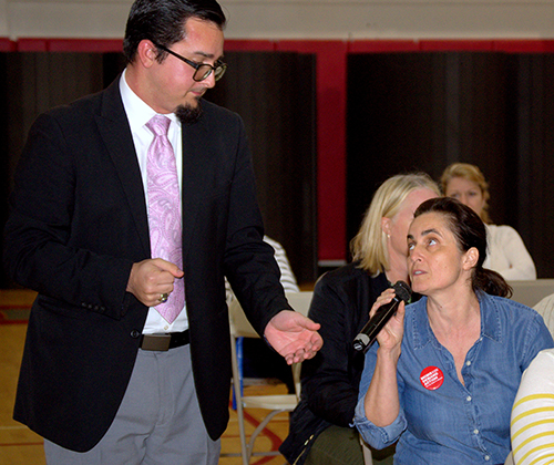 Christina Rodrigues tells assistant principal Oscar Cedeño about a mothers’ group for gun control during a session on coping with active shooter situations at Cardinal Gibbons High School.