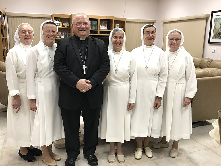 Auxiliary Bishop Peter Baldacchino is pictured here with the Sisters of St. Joseph Benedict Cottolengo who staff the Marian Center in Miami Gardens and the Hope Outreach Center in Davie. He joined them for Mass and dinner on the occasion of their annual renewal of their vows, this year on the feast of the baptism of the Lord.