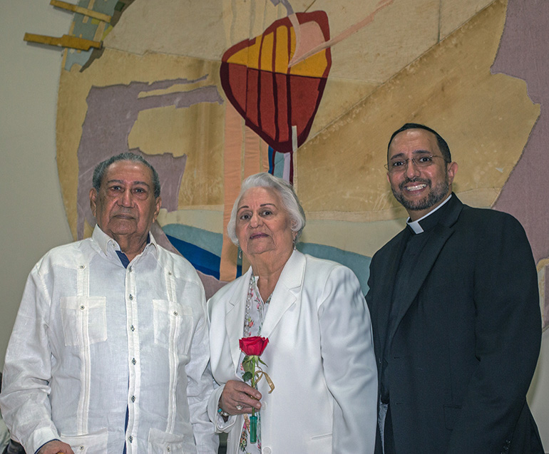 Martin and Ozema De Jesus, married 68 years, pose for a photo with their son, Father Julio De Jesus, administrator of St. Benedict Church in Hialeah.