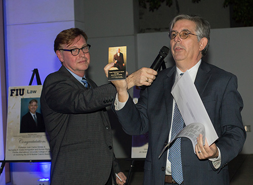 Randolph McGrorty, CEO of Catholic Legal Services, holds the microphone for Mother Cabrini Award recipient Juan Carlos Gomez of Florida International University, who held up a copy of the U.S. Constitution during his acceptance speech.