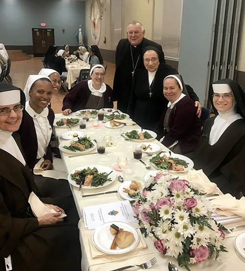 Archbishop Thomas Wenski poses with members of two religious communities, the Servants of the Pierced Hearts of Jesus and Mary and the Carmelites of the Most Sacred Heart of Los Angeles, at the dinner that followed the annual Mass for the World Day of Consecrated Life, Feb. 2 at St. Mary Cathedral.