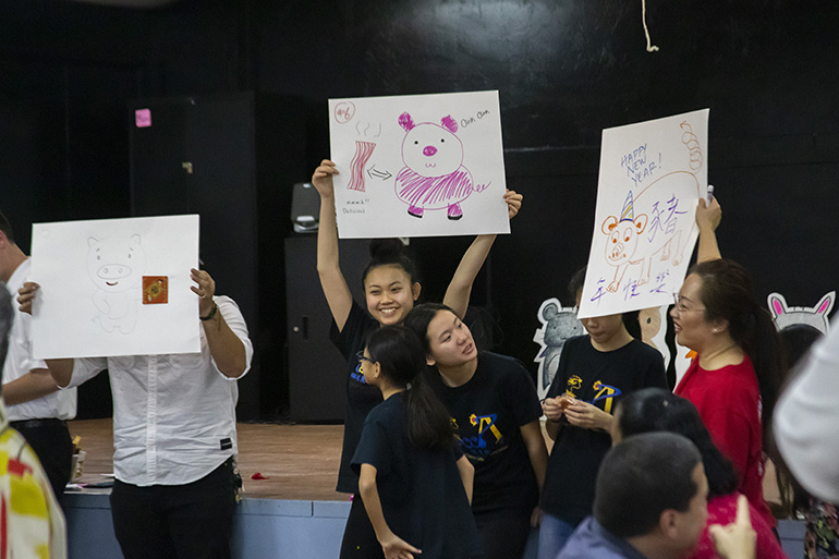 Kids participate in a game during the reception that followed the Chinese New Year Mass. The game consisted of drawing pictures of a pig, the Chinese Zodiac animal for this lunar year.