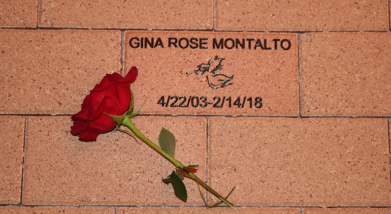 A red rose is placed on a brick near the Mary Help of Christians Church entrance in Parkland, bearing the name of Gina Rose Montalto. Gina, 14, whose family are parishioners, was killed in the shooting at Marjory Stoneman Douglas High School.