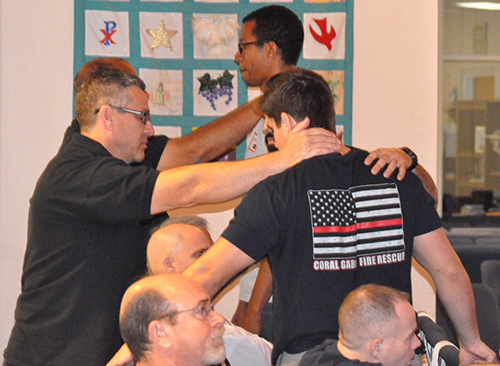 Men pray for each other during one of the ManUp conferences held at St. Edward Church in Pembroke Pines.