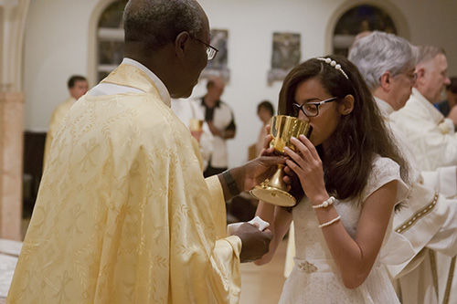 Jennifer Ortiz, then 12, celebrates her first Communion during the Easter Vigil Mass at St. Mary Cathedral back in 2016. Members of St. Anthony Parish's Women's Guild are now praying individually for each of the 26 children in the religious education program who will make their first Communion March 2.