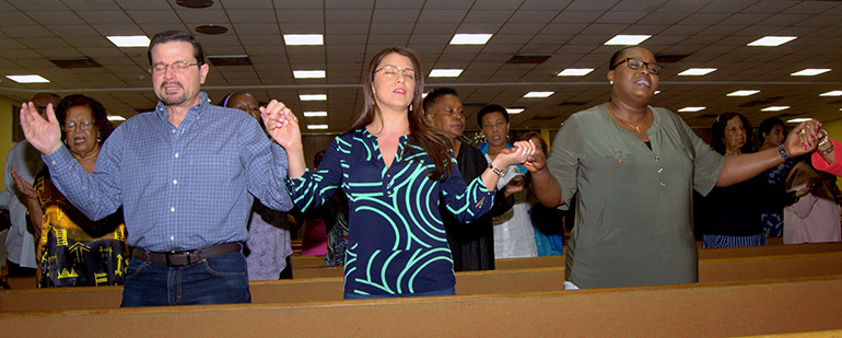 Worshipers join hands to pray during a revival at St. Bernard Church presented by the archdiocesan Office of Black Catholics.