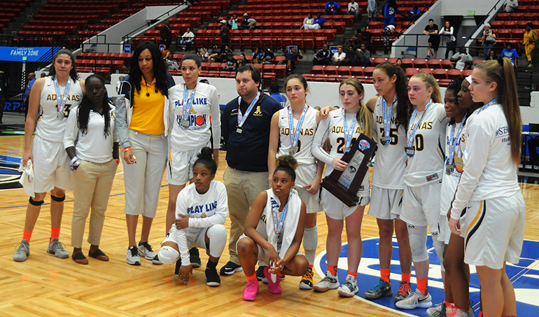 St. Thomas Aquinas coach Oliver Berens and his team pose with the state runner-up trophy after the Raiders lost 58-52 in overtime to Tampa Bay Tech on Saturday, March 2, in the FHSAA Class 8A state girls basketball championship game at the RP Funding Center in Lakeland.