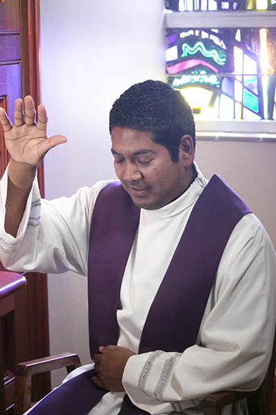 Father Juan Gomez, parochial vicar at St. James Church in North Miami, acts as if he is imparting absolution during the taping of a Reconciliation Weekend promotional video at St. Mary Cathedral.
