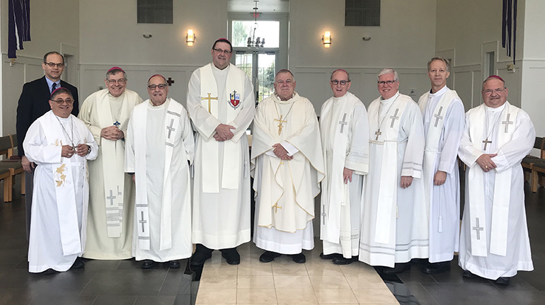 Michael B. Sheedy, executive director of the Florida Catholic Conference, poses with all the bishops of Florida after they celebrated Mass at their annual December gathering in 2018, at the Bethany Retreat Center near Tampa. From left: Sheedy, Miami Auxiliary Bishop Enrique Delgado, Palm Beach Bishop Gerald Barbarito, St. Augustine Bishop Felipe Estevez, St. Petersburg Bishop Gregory Parkes, Archbishop Thomas Wenski, Orlando Bishop John Noonan, Venice Bishop Frank Dewane, Pensacola-Tallahassee Bishop William Wack, and Miami Auxiliary Bishop Peter Baldacchino.