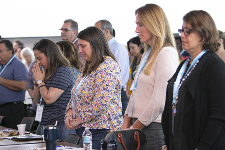 Participants pray at the start of the keynote talk by Sister Miriam James Heidland of the Sisters of Our Lady of the Most Holy Trinity, during the archdiocesan Evangelization Summit, March 16, 2019, at Msgr. Edward Pace High School in Miami Gardens.