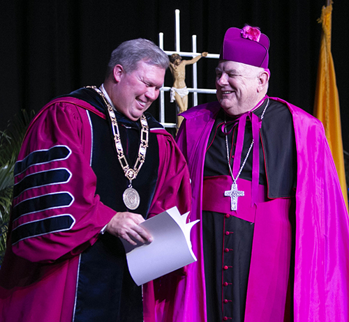 Archbishop Thomas Wenski and David A. Armstrong share a laugh at the conclusion of Armstrong's inauguration as 10th president of St. Thomas University, Miami Gardens, March 20, 2019.