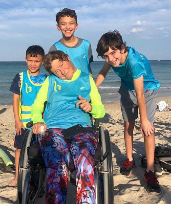 Youths take part in the April 14 South Beach Triathlon along with disabled athlete Kerry Gruson, center. The boys, from left, are Anthony and Lewis Perez, students at St. Mark School; and their friend Esteban Bird, a student at Mater Grove Academy in Miami.