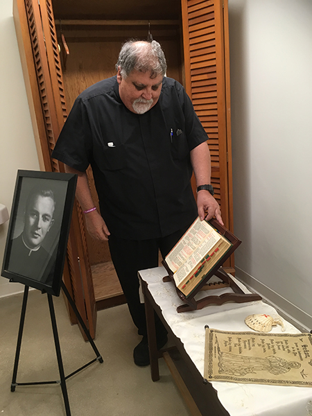 El P. Jos&eacute; Espino, p&aacute;rroco de San L&aacute;zaro en Hialeah admira algunos objetos que pertenecieron a Mons. Bryan Walsh, como su Misal Romano y una concha de Santiago de Compostela. Estos objetos fueron obtenidos por la organizaci&oacute;n Pedro Pan Group a trav&eacute;s de donaciones, hora est&aacute;n expuestos en la reci&eacute;n renovada capilla del Campamento Matecumbe, en Kendall.