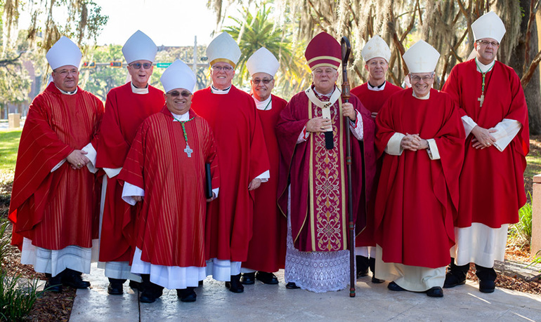 Florida's bishops pose outside the Co-Cathedral of St. Thomas More before celebrating the annual Red Mass of the Holy Spirit March 27, 2019 in Tallahassee. From left: Miami Auxiliary Bishop Peter Baldacchino, Orlando Bishop John Noonan, Miami Auxiliary Bishop Enrique Delgado, Venice Bishop Frank Dewane, St. Augustine Bishop Felipe Estevez, Archbishop Thomas Wenski, Pensacola-Tallahassee Bishop William Wack, Palm Beach Bishop Gerald Barbarito and St. Petersburg Bishop Gregory Parkes.