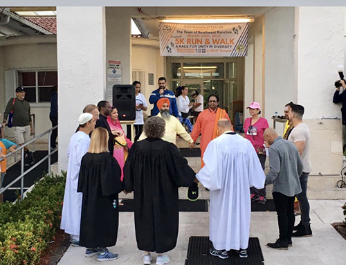 Leaders from 10 religious institutions in Southwest Ranches, including Archbishop McCarthy High, St. Mark Church and School, and the Archdiocese of Miami, take part in a unity prayer before the start of the 5K Run and Walk March 30.