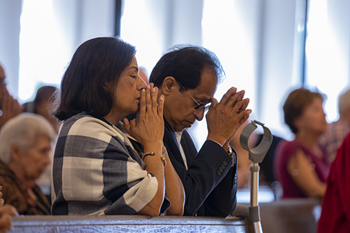 Mary and George Vells, parents of pastor Father Biju Vells, pray during the Mass celebrated by Archbishop Thomas Wenski in commemoration of the 60th anniversary of St. Pius X Church in Fort Lauderdale.