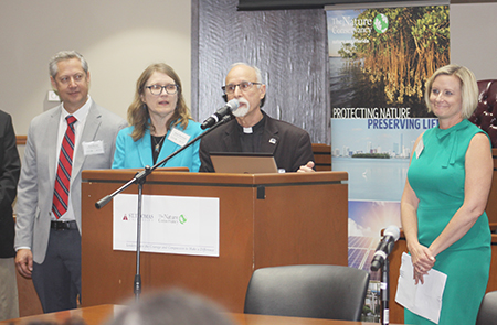 Father Alfred Cioffi, professor of biology and bioethics at St. Thomas University, welcomes participants to the Second International Conference on Climate, joined by members of The Nature Conservancy, who teamed up with St. Thomas to organize the conference, held April 4 and 5. Father Cioffi is at center, with, from left, The Nature Conservancy members Rod Braun, Janet Bowman and Temperince Morgan.