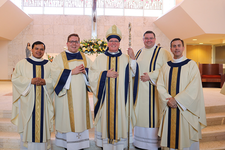 Bishop Frank J. Dewane of Venice and Msgr. David Toups, far right, rector of St. Vincent de Paul Regional Seminary in Boynton Beach, pose with Father Elvis Gonzalez, far left, Archdiocese of Miami vocations director, after ordination of the archdiocese's new transitional deacons, Andrew Tomonto (second from left) and Ryan Saunders (second from right.) The seminarians were ordained April 6 at St. Joan of Arch Church in Boca Raton, part of a class of 15 currently studying for the priesthood at the seminary.